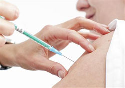 un sanitario recibe la vacuna contra la gripe A en un hospital de Chur, en el este de Suiza, el 11 de noviembre de 2009.
