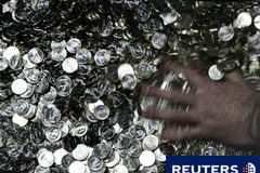 El déficit del Estado baja un 18,9% en el primer semestre Un trabajador de la Casa de la Moneda mueve monedas de 1 euro en la sede del organismo en Madrid el 6 de noviembre de 2008.