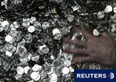 Un trabajador de la Casa de la Moneda mueve monedas de 1 euro en la sede del organismo en Madrid el 6 de noviembre de 2008.