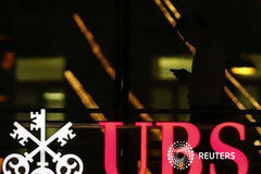 UBS pagará 1.500 millones por manipular el Libor y admite fraude En la imagen del 17 de diciembre se puede ver a un empleado usando un móvil al pasar ante el logo de UBS en la ciudad suiza de Zúrich.