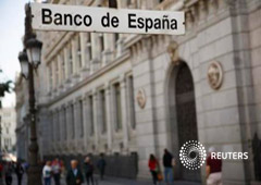Gente caminando junto a la sede del Banco de España en Madrid