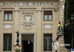 Un operario subido en una grúa poda un árbol en el exterior del Banco de España en Sevilla, el 21 de febrero de 2013