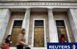 Los griegos van a la huelga contra la reforma de las pensiones varias personas caminan junto al Banco de Grecia en Atenas, el 18 de mayo de 2010.