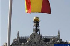 La rebaja a España aumenta la presión sobre la UE para que actúe Una bandera epañola con el edificio del Banco de España al fondo en Madrid