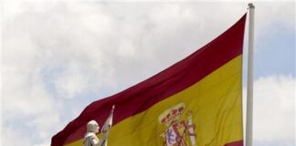 El déficit por cuenta corriente baja un 80% interanual en junio La estatua de Cristóbal Colón junto a una bandera de España en el centro de Madrid