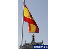 Una bandera epañola con el edificio del Banco de España al fondo en Madrid, el 10 de marzo de 2011