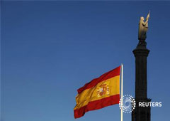 una bandera española ondea en Madrid, cerca de la estatua de Colón