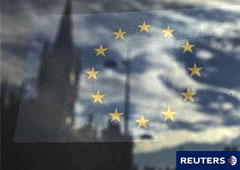 La bandera de la Unión Europea es fotografiada en una ventana que refleja una calle