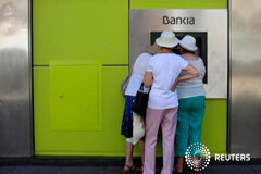 Bankia devolverá a los minoristas su inversión por la salida a bolsa Gente usa un cajero de Bankia en Sevilla, el 24 de junio de 2013