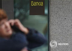Una mujer habla pr teléfono frente a una sucursal de Bankia en Madrid, el 26 de octubre de 2012.