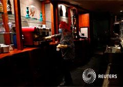 Maria Vazquez wears a face mask as she cleans her restaurant before trying to reopen it from May 11, as some Spanish provinces are allowed to ease restrictions amid the coronavirus disease (COVID-19) outbreak, in Guadalajara, Spain, May 10, 2020