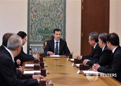 El presidente sirio, Bashar el Asad (C), preside una reunión con nuevos ministros en Damasco, en una fotografía distribuida por la agencia nacional SANA el 25 de agosto de 2013