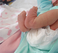 Un bebé con las piernas encogidas.