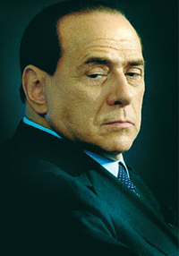 Berlusconi haciendo un gesto de llamar con la mano.