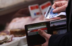 España siguió en recesión en el cuarto trimestre de 2009 Un hombre saca un billete de 20 euros para pagar en una carnicería.