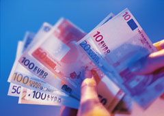 Una mano sosteniendo varios billetes de euro.