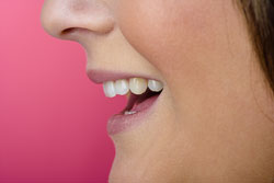 Primer plano de una boca con el fondo rosa