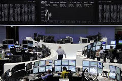 Las bolsas europeas ceden por temores sobre crecimiento global Operadores sentados en sus mesas frente a la pantalla con el índice DAX en la Bolsa de Fráncfort