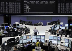 Operadores sentados en sus mesas frente a la pantalla con el índice DAX en la Bolsa de Fráncfort