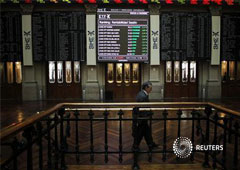 Un operador pasa frente a unas pantallas en la bolsa de Madrid