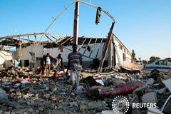 Mueren al menos 40 personas en bombardeo a un centro de migrantes en Trípoli Los migrantes cargan los restos de sus pertenencias entre los escombros en un centro de internamiento de migrantes, golpeado por un ataque aéreo en el suburbio de Tajoura, en la capital libia de Trípoli, Libia, el 3 de julio de 2019