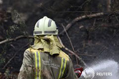 El presidente de Galicia pide endurecer las penas por incendios Un bombero refrescando el terreno en el parque situado en el consejo de A Capela, en la provincia de Coruña