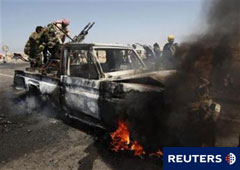 Combatientes rebeldes montados en un coche en llamas el 5 de abril en las afueras de Brega.