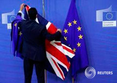 Un trabajador retira las banderas británicas y de la UE en Bruselas el 17 de julio de 2017