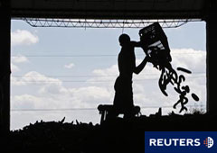Un trabajador tira pepinos para destruirlos en una instalación agrícola cerca de Bucarest el 6 de junio de 2011.