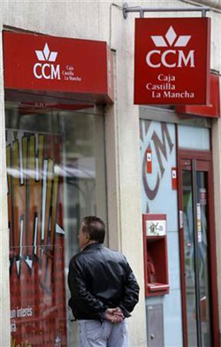 un hombre observa una sucursal de CCM en Madrid, el 30 de marzo de 2009.