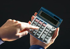 Una mano tecleando en una calculadora.