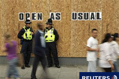 Los británicos buscan respuestas tras calmarse los disturbios Imagen del 10 de agosto de unos policías junto a una tienda protegida en Streatham, en el sur de Londres.