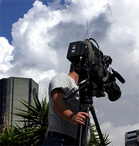 Un hombre grabando con una cámara de rodaje profesional.