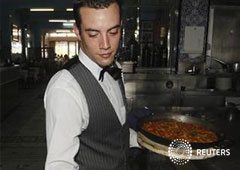 En la imagen de archivo, un camarero muestra una paella en un restaurante de la playa de la Malvarrosa en Valencia, el 20 de julio de 2012