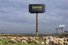 Guindos: Los tenedores de preferentes podrían recibir toda su inversión En la imagen, un rebaño pasta junto a un cartel de Bankia en Sevilla el 4 de diciembre de 2012.