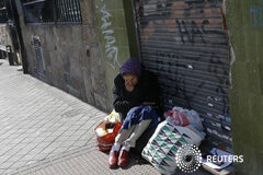 Cáritas atendió a 1,8 millones de personas en 2011 por la crisis Imagen de una mujer sentada ante una tienda cerrada en Madrid el 22 de octubre