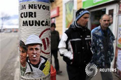 Mayor optimismo empresarial en la eurozona, pero el paro sube más En la imagen, varias personas pasan junto a un cartel que demanda más trabajo en Zlatna, a 420 km al noroeste de Bucarest el 8 de diciembre de 2012