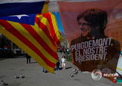 Un cartel en apoyo de Carles Puigdemont junto a una bandera independentista en Barcelona el 28 de marzo de 2018