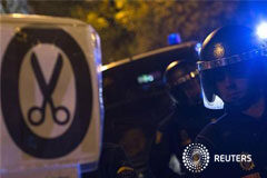El Congreso aprueba unos presupuestos austeros para 2013 En la imagen, varios policías junto a un cartel contra los recortes en Madrid el 19 de diciembre de 2012