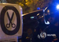 En la imagen, varios policías junto a un cartel contra los recortes en Madrid el 19 de diciembre de 2012