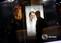 Carteles electorales del presidente del Gobierno, Mariano Rajoy (delante) y el líder socialista Pedro Sánchez, dos de los cuatro principales candidatos de las elecciones del 20 de diciembre, en una estación de cercanías en Madrid, el 11 de diciembre de 20