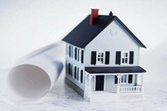 Los bancos y su responsabilidad en los desastres sobre plano (I) Una casa en miniatura junto a un plano