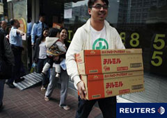 Una familia compra cajas de leche en polvo japonesa en una tienda de Hong Kong, el 15 de marzo de 2011.