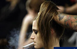 El Congreso admite a trámite endurecer la ley del tabaco una modelo fuma mientras la peinan antes de desfilar en la pasarela Cibeles en Madrid, el 23 de febrero de 2010.