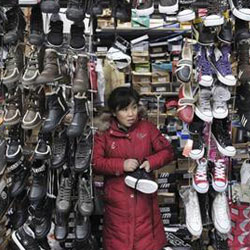 una vendedora espera por clientes en su puesto de zpaatos en un mercado en Shenyang, en la provincia de Liaoning, el 21 de enero de 2010. una vendedora espera por clientes en su puesto de zpaatos en un mercado en Shenyang, en la provincia de Liaoning, el 21 de enero de 2010.