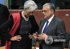 La directora general del FMI, Christine Lagarde (I), habla con el primer ministro griego, Lucas Papademos (D), al inicio de la reunión del Eurogrupo en la sede de la Unión Europea, en Bruselas, el 20 de febrero de 2012.