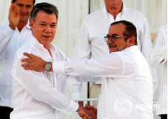 Santos (izq) y Londoño (dcha) se dan la mano tras la firma del primer acuerdo de paz en Cartagena de Indias, el 26 de septiembre de 2016
