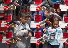 Miembros de una familia miran pistolas en el Centro de Convenciones George R. Brown, el lugar de reunión anual de la Asociación NAcional del Rifle de Estados Unidos, en Houston, Texas, el 4 de mayo de 2013