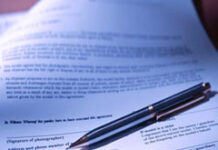 El límite a la libre transmisibilidad de acciones en la S.A.: las cláusulas de autorización Contrato en papel con un bolígrafo encima.