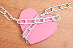 En el tercer trimestre del año aumentaron las denuncias por violencia de género y las condenas a los maltratadores Un corazón rosa con unas cadenas.